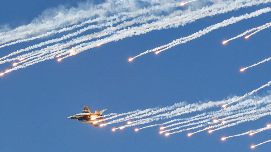 General Dynamics F-16 Fighting Falcon multirole fighter aircraft release flares as they perform aerial manuevers during the 2021 Dubai Airshow in the Gulf emirate on November 14, 2021. (Photo by Giuseppe CACACE / AFP) (Photo by GIUSEPPE CACACE/AFP via Getty Images)