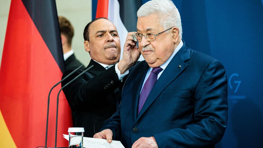 Palestinian President Mahmud Abbas (R) is helped with the headphones at the start of a joint press conference with Germany's Chancellor at the Chancellery in Berlin on August 16, 2022. (Photo by JENS SCHLUETER / AFP) (Photo by JENS SCHLUETER/AFP via Getty Images)