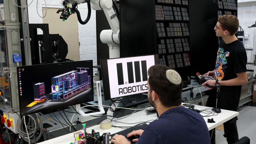 Technicians work at the headquarters of the Israeli company 1MRobotics, in the Israeli coastal city of Tel Aviv on, January 11, 2023. - Behind a seemingly ordinary storefront in Tel Aviv, the Israeli company is speeding up online shopping by replacing staff with robots that manoevure around small, streetside storerooms. (Photo by JACK GUEZ / AFP) (Photo by JACK GUEZ/AFP via Getty Images)