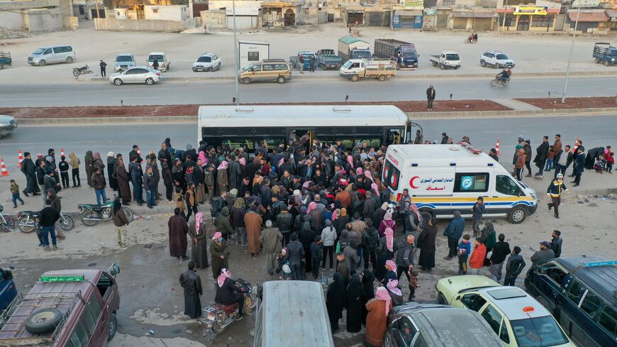 An aerial picture shows Syrian refugees living in Turkey waiting to take a bus through the northern Bab al-Hawa border crossing, on February 17, 2023, as they return to Syria in the aftermath of a deadly earthquake. - Turkey this week allowed Syrians under its protection who hold ID cards from one of the quake-hit provinces to leave for between three and six months, a rule change designed to reunite families on both sides of the border hit by the February 6 disaster, which has killed more than 41,000 people