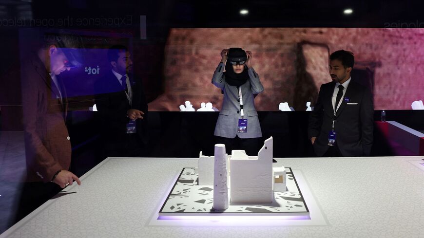 Visitors use an augmented reality mask on the Saudi Arabia company STCs stand at the Mobile World Congress (MWC), the telecom industry's biggest annual gathering, in Barcelona on February 27, 2023. (Photo by Thomas COEX / AFP) (Photo by THOMAS COEX/AFP via Getty Images)