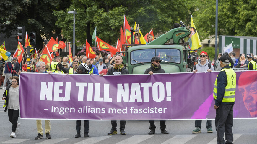 Activists of the "Alliance against NATO" network hold a banner reading "No to NATO! - No alliance with fascists" during a demonstration for freedom of speech and association, in support of democratic forces in Turkey and against Swedish NATO membership, on June 4, 2023 in Stockholm, Sweden. Hundreds of protesters took to the streets in Stockholm city centre to demonstrate against Sweden's NATO bid and new anti-terror legislation, despite Ankara's objections. (Photo by Maja SUSLIN / TT News Agency / AFP) / S