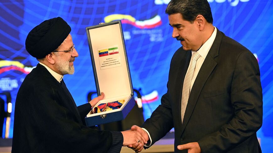 Iranian President Ebrahim Raisi (L) receives a commemorative decoration from Venezuelan President Nicolas Maduro, after a joint press statement at Miraflores Presidential Palace in Caracas, on June 12, 2023.