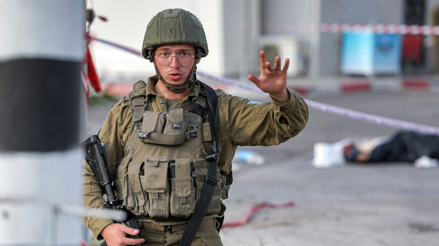 An Israeli soldier gestures at the scene of an attack near the Jewish settlement of Eli.