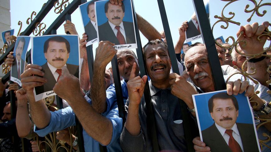 Members of the People's Mujahedin Organisation of Iran (PMOI) hold the picture of a deceased person.