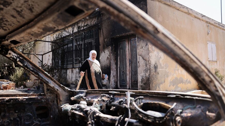 A Palestinian woman carries a piece of wood as she stands outside her house, which was set on fire by Israeli settlers the day before, in Turmus Aya near the occupied West Bank city of Ramallah, on June 22, 2023. A resident of Turmus Ayya told AFP around "200 settlers" attacked the Palestinian village, while AFP journalists in the village saw scorched homes, buildings and wounded people being evacuated by ambulance. (Photo by AHMAD GHARABLI / AFP) (Photo by AHMAD GHARABLI/AFP via Getty Images)