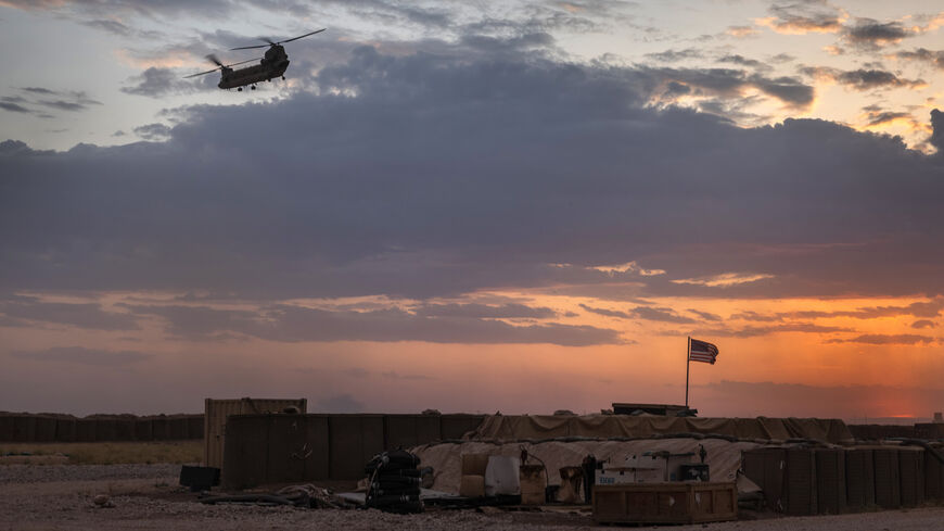 A US Army CH-47 Chinook helicopter takes off at sunset while transporting American troops out of a remote combat outpost known as RLZ near the Turkish border in northeastern Syria, May 25, 2021.