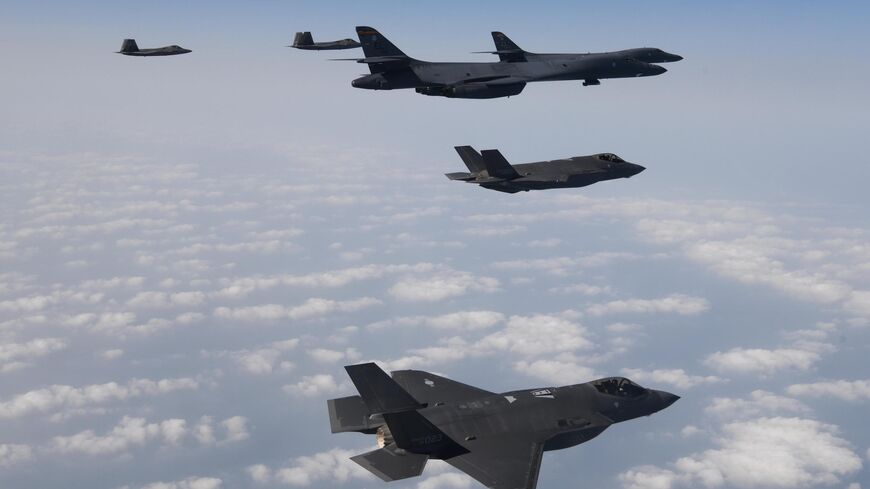 In this handout image released by the South Korean Defense Ministry, U.S. Air Force B-1B bombers (R), F-22 fighter jets and South Korean Air Force F-35 fighter jets (bottom) fly over South Korea Peninsula during a joint air drill on February 01, 2023 at an undisclosed location in South Korea. 