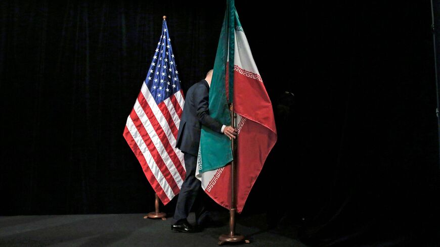 A staff removes the Iranian flag from the stage after a group picture with foreign ministers and representatives of Unites States, Iran, China, Russia, Britain, Germany, France and the European Union during the Iran nuclear talks at the Vienna International Center in Vienna on July 14, 2015.