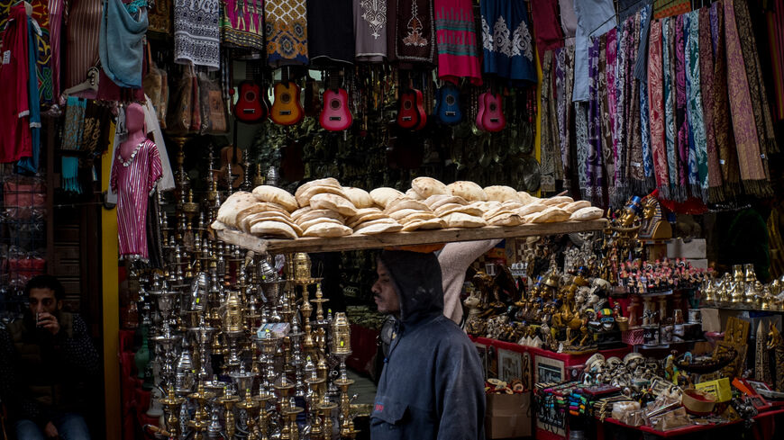 A man carries a tray of bread through a market street on Dec. 14, 2016, in Cairo, Egypt.