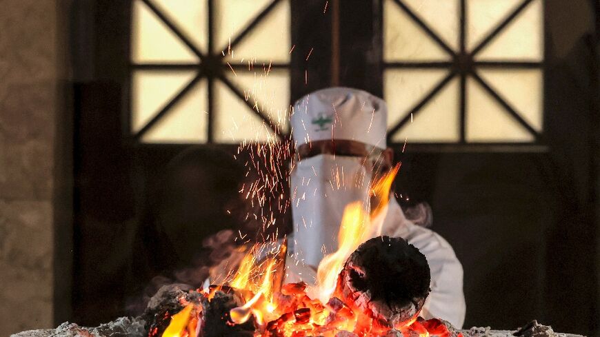 A Zoroastrian priest adds wood to the Atash Bahram ("Fire of Victory" or Eternal Flame) in the sanctum at the Fire Temple of Yazd in central Iran