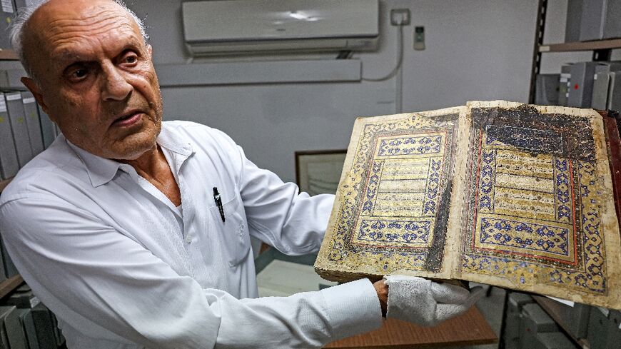 Librarian Khader Salameh with a gilded copy of the Koran from the 16th century