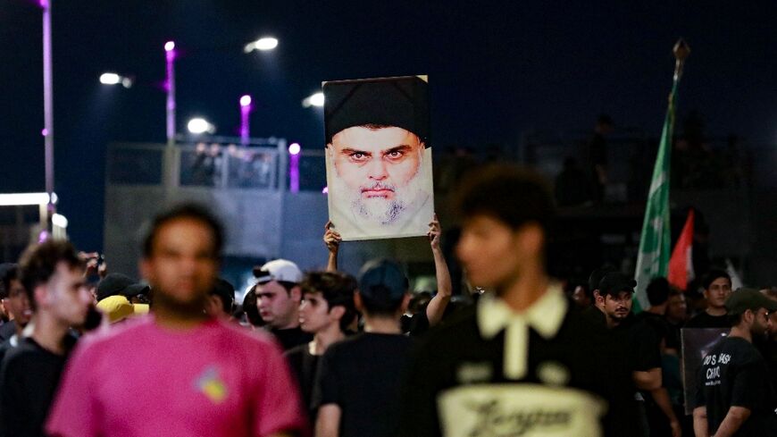 Followers of Iraqi Shiite cleric Moqtada Sadr hold his portrait aloft during a protest after they believed a Koran had been desecrated in Denmark