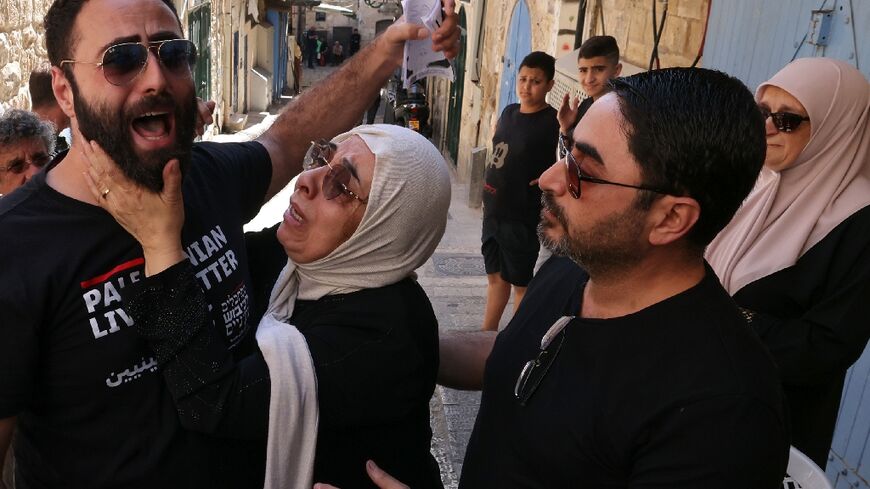 Nora Sub Laban (C) and her sons Raafat (L) and Ahmad after their eviction