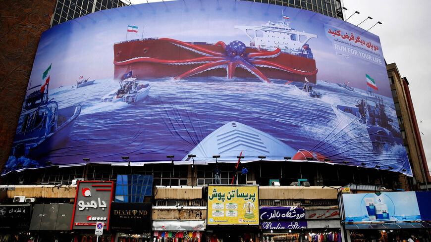 A billboard depicts Iranian Revolutionary Guard Corps navy units observing a US warship in the Gulf of Oman, Vali-Asr Square in Tehran, Iran, Nov. 5, 2021.