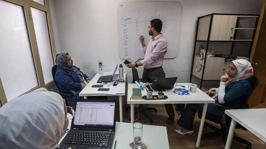 This picture taken on September 12, 2021 shows a view of the company offices of "al-Gameya", a tech startup the runs an app to facilitate for strangers to create an informal money-pooling association to provide access for money in time of need, points a screen showing to the application's online portal at the company offices, in Egypts capital Cairo. - Cash-strapped Egyptians fearful of banks have long relied on a "gameya" to access money in time of need, but now tech startups are cashing in on the practice