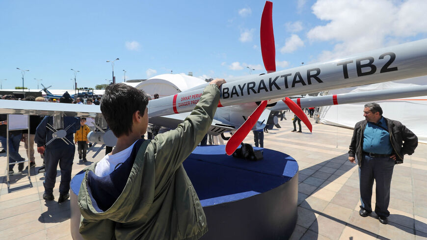 A young man looks at the Bayraktar TB2 drone, manufactured by Turkey's Baykar, as it is presented during the opening of the Teknofest Azerbaijan aerospace and technology festival at Baku Crystal Hall, Baku, Azerbaijan, May 27, 2022.