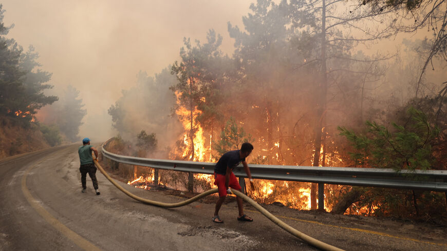 Volunteers help to extinguish a wildfire that broke out in the Datca district of Mugla, Turkey, July 13, 2022.