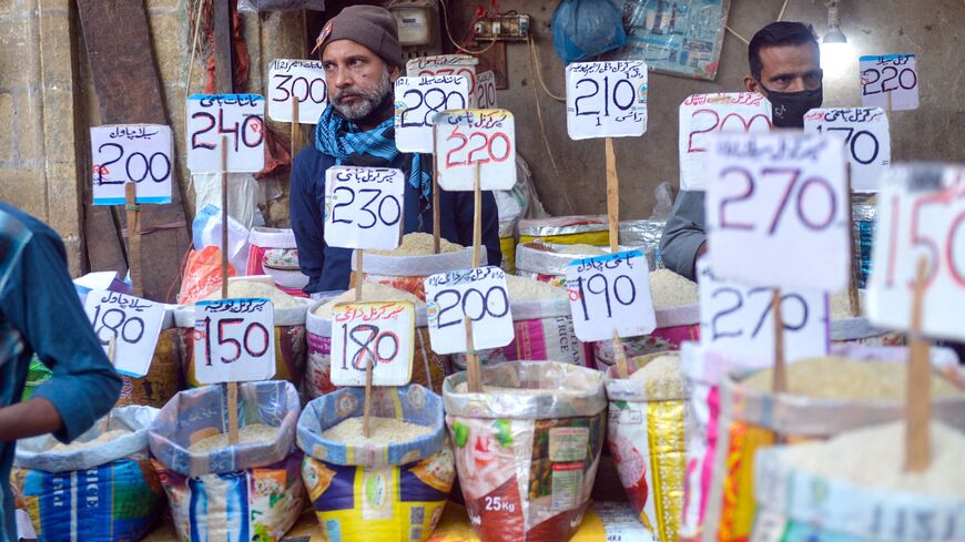 Shopkeepers fix the price tags of rice at a market in Karachi on Jan. 6, 2023. 