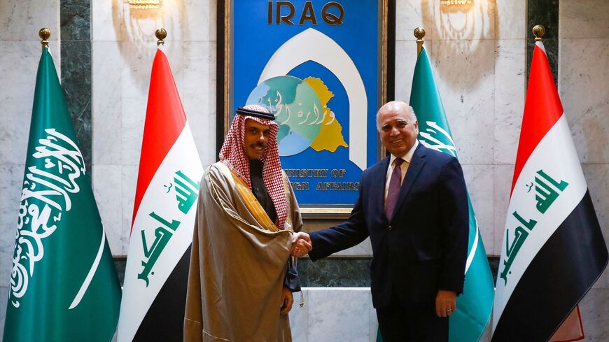 Iraq's Foreign Minister Fuad Hussein (R) shakes hands with his Saudi counterpart, Faisal bin Farhan Al Saud, in Baghdad on Feb. 2, 2023.