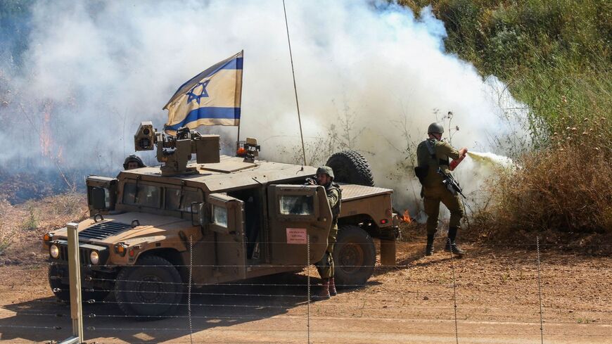An Israeli soldier extinguishes a bush fire caused by a Molotov cocktail.