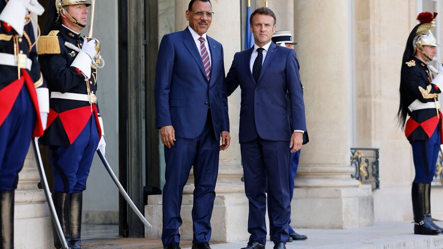 French President Emmanuel Macron (R) greets Niger's President Mohamed Bazoum as he arrives for a meeting at the Elysee Palace, amid the New Global Financial Pact Summit in Paris on June 23, 2023. (Photo by Ludovic MARIN / AFP) (Photo by LUDOVIC MARIN/AFP via Getty Images)