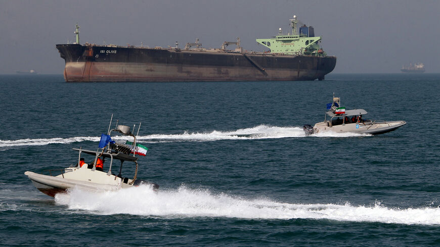 Iranian Revolutionary Guard speedboats cruise past an oil tanker off the port of Bandar Abbas, southern Iran, on July 2, 2012. Iran has come up with several methods to foil the European insurance embargo on ships loaded with its crude, a sanction which may harm its vital exports as much as the EU oil embargo itself. AFP PHOTO/ATTA KENARE (Photo credit should read ATTA KENARE/AFP/GettyImages)