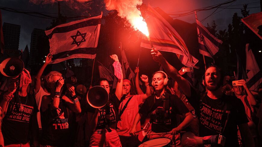 A demonstrator from the "Pink Front" group lights a flare.