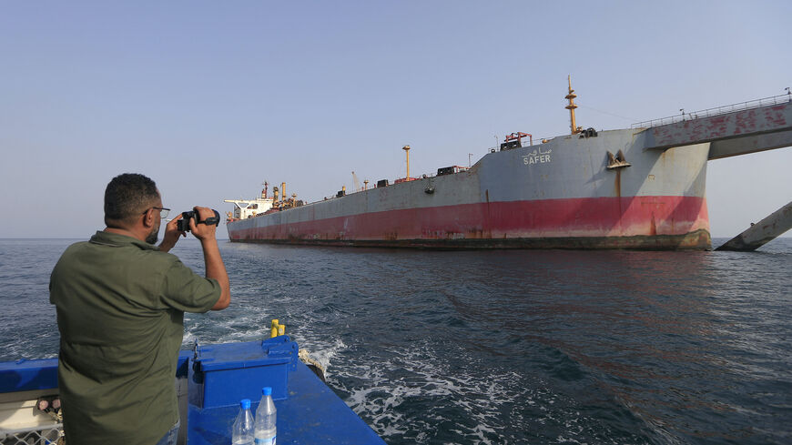 A man snaps a picture of the beleaguered Yemen-flagged FSO Safer oil tanker in the Red Sea off the coast of Yemen's contested western province of Hodeida on July 15, 2023.