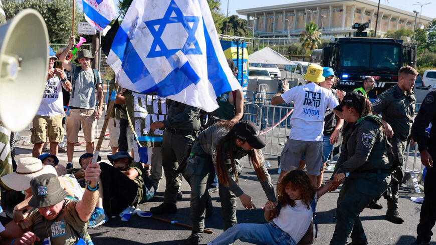 Members of Israel's security forces remove protesters blocking the Knesset entrance amid a monthslong wave of protests against the government's planned judicial overhaul, Jerusalem, July 24, 2023.