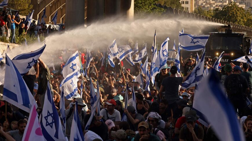 Israeli security forces use a water cannon to disperse demonstrators blocking the entrance of the Knesset.