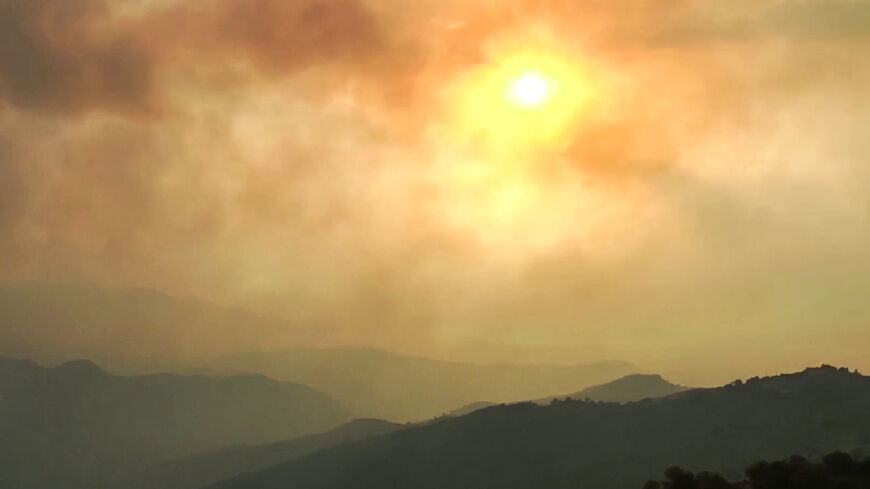 This image grab taken from AFPTV video footage shows smoke clouds covering the sky during wildfires in the forests of Bejaia in northern Algeria.