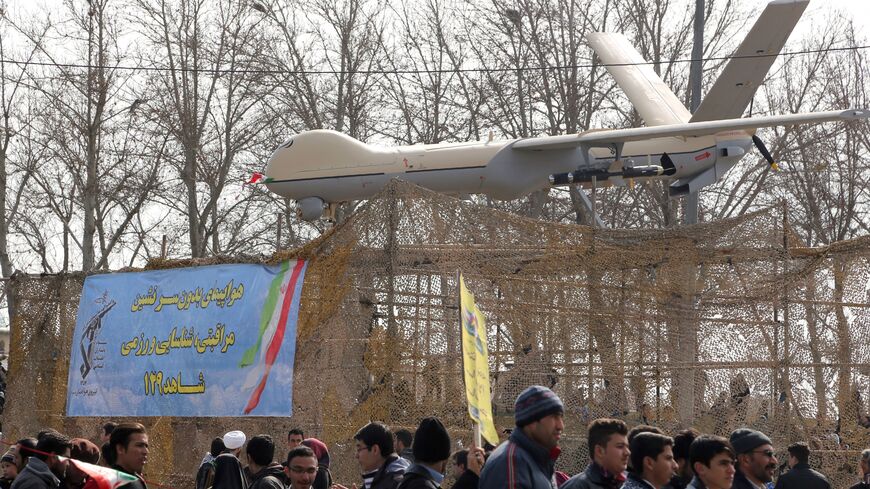 Iranians walk past Iran's Shahed 129 drone during celebrations in Tehran to mark the 37th anniversary of the Islamic revolution on February 11, 2016. Iranians waved "Death to America" banners and took selfies with a ballistic missile as they marked 37 years since the Islamic revolution, weeks after Iran finalised a nuclear deal with world powers. (Photo by ATTA KENARE / AFP) (Photo by ATTA KENARE/AFP via Getty Images)