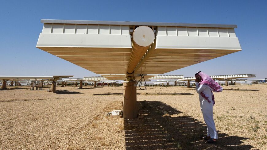 TOPSHOT - A Saudi man talks on his mobile under the shade of solar panel at a solar plant in Uyayna, north of Riyadh, on March 29, 2018. On March 27, Saudi announced a deal with Japan's SoftBank to build the world's biggest solar plant. / AFP PHOTO / FAYEZ NURELDINE (Photo credit should read FAYEZ NURELDINE/AFP via Getty Images)