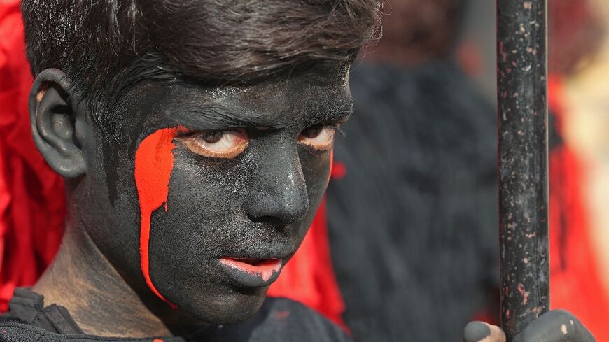 A boy with his body painted black portrays a jinn