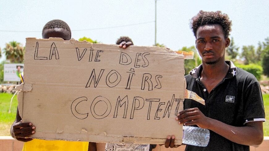 Migrants display the slogan "Black Lives Matter" in French at a protest in Sfax