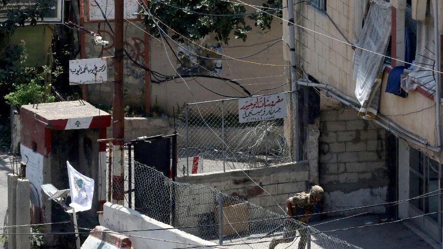 A Lebanese soldier takes cover at the entrance to Ain al-Helweh