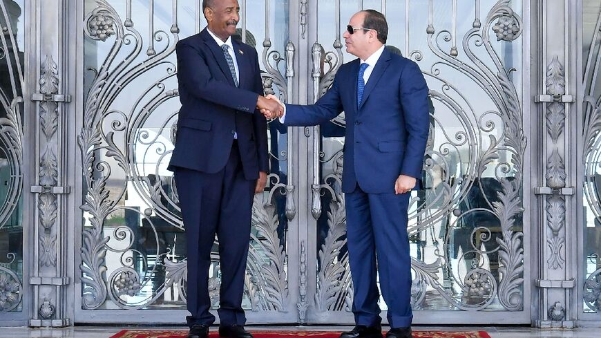 Egyptian President Abdel Fattah al-Sisi (R) receives Sudanese General Abdel Fattah al-Burhan in El Alamein