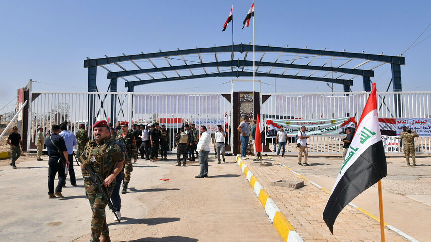 Members of the Syrian security forces gather on the Syrian side of the border-crossing between Albu Kamal in Syria and Al-Qaim in Iraq, on September 30, 2019, after the crossing re-opened today after it was seized by the Islamic State (IS) group jihadists in 2014. (Photo by AFP) (Photo by -/AFP via Getty Images)