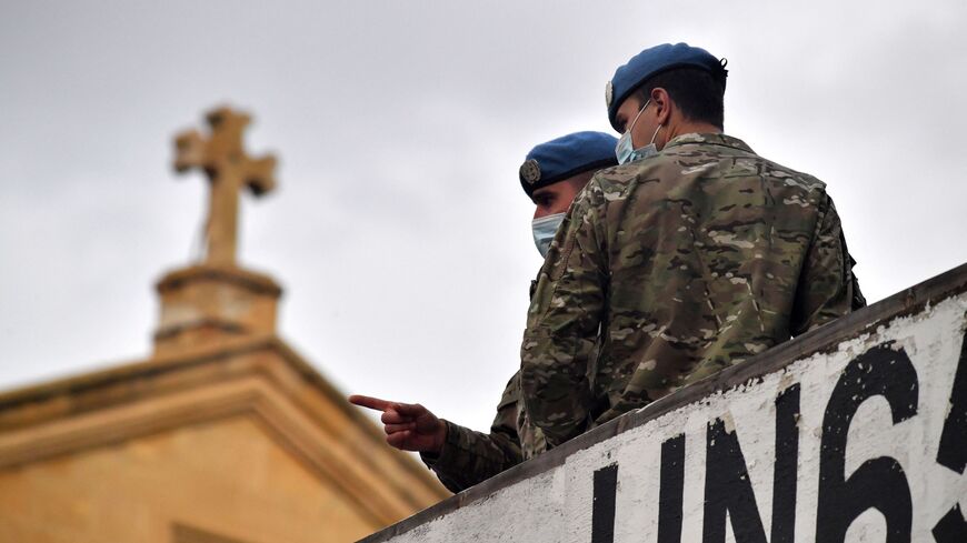 Peacekeepers look on from the UN65 Checkpoint of the United Nations Buffer Zone opposite the Roman Catholic Church of the Holy Cross in the divided old walled city of Cyprus' capital Nicosia where the Pope will hold an ecumenical prayer with migrants, on Dec. 3, 2021. 