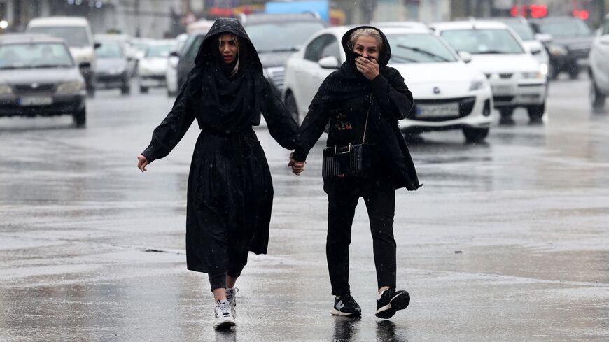 Iranian women walk in the street on a rainy day in the capital Tehran, on December 4, 2022. - Iran has scrapped its morality police after more than two months of protests triggered by the death of Mahsa Amini following her arrest for allegedly violating the country's strict female dress code, local media said Sunday.women (Photo by Atta KENARE / AFP) (Photo by ATTA KENARE/AFP via Getty Images)