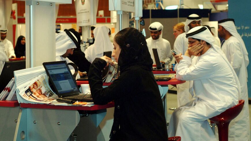 Emiratis work at the Middle East's largest technology exhibition, GITEX, which opened in Dubai Oct, 3, 2004. 