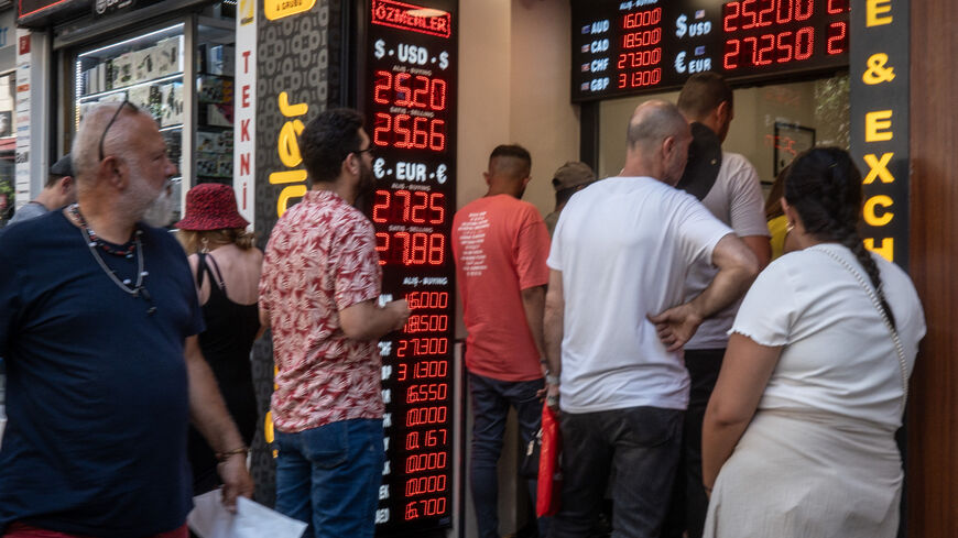 People wait to exchange money at a currency exchange shop on June 23, 2023 in Istanbul, Turkey.