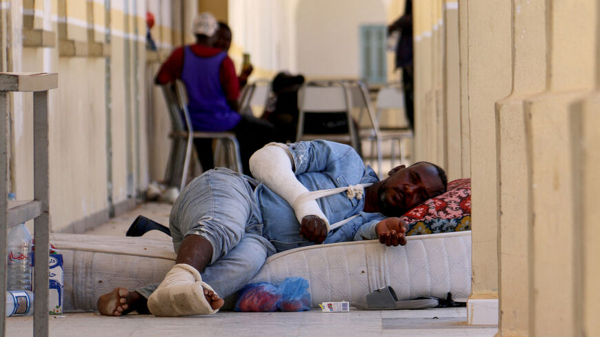 An injured migrant who fled violence in Sfax to the militarised buffer zone between Tunisia and Libya rests.