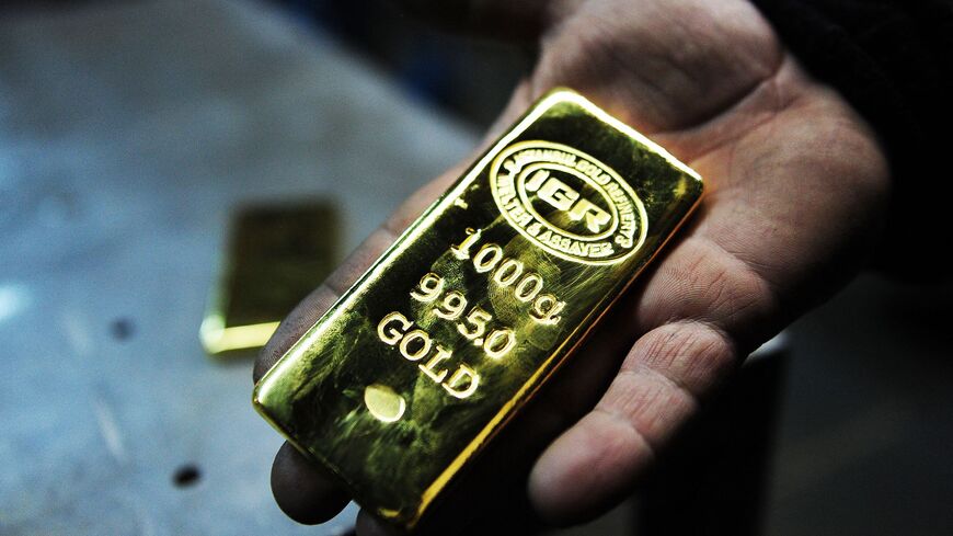 A gold worker holds a 1 KG gold bullion at Istanbul Gold Refinery (IGR) on January 13, 2015 in Istanbul. 