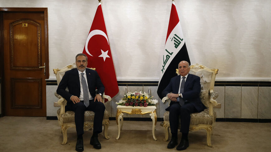 Iraq's Foreign Minister Fuad Hussein (R) poses with Turkey's Foreign Minister Hakan Fidan in Baghdad on Aug. 22, 2023. 