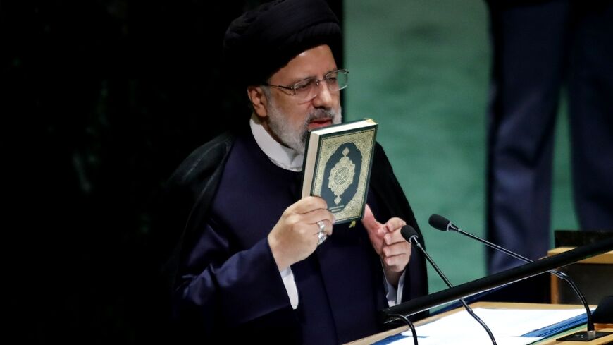 Iranian President Ebrahim Raisi holds the Koran as he addresses the United Nations General Assembly