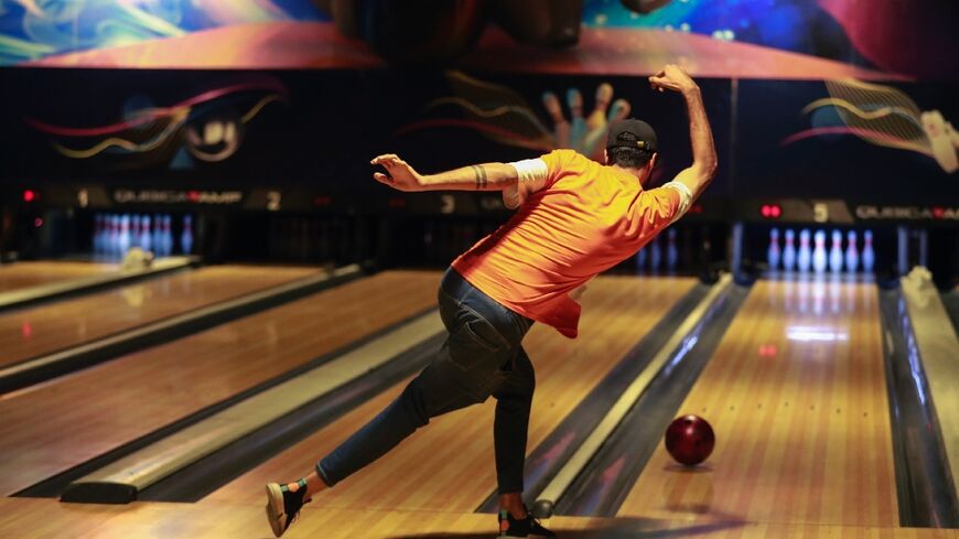 An Iraqi delivers a ball at a bowling alley in Baghdad
