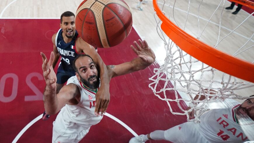 Hamed Haddadi (C) battling under the basket against France at the Tokyo Olympics 