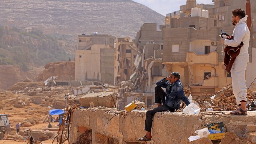 A survivor sits on the rubble of a destroyed building in Derna, a city devastated by a tsunami-sized flash flood